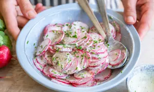 Frischer Radieschen Salat mit Schnittlauch und einer cremigen Soße, bereit zum Servieren.