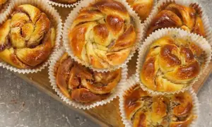 Nybakade bullar med mandelmassa och vallmofrön, gyllene och glansiga i sina pappersformar.