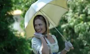 Uśmiechnięta młoda kobieta w białej sukience i rękawiczkach trzyma parasolkę. Scena z filmu "Śluby panieńskie" obsada.