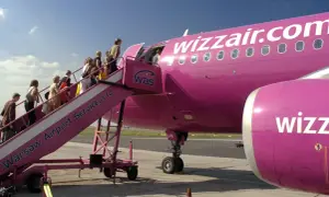 Pasażerowie wsiadają do różowego samolotu Wizzair. Kiedy odprawa online? Już teraz!