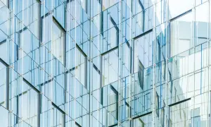 Nowoczesna fasada budynku z tafli szkła, przypominająca wytrzymałość **gorilla glass**.