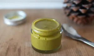 Un pot de pâte de pistache maison, prêt à être dégusté. Une recette simple pour un délice gourmand.