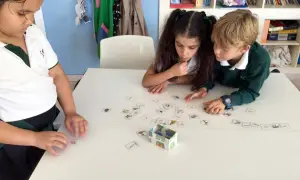 Niños concentrados en juegos de verbos con tarjetas de imágenes.