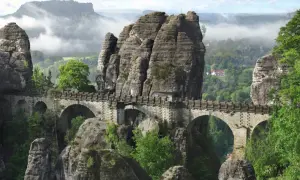 Kamienny most Bastei, jedna z najpiękniejszych atrakcji turystycznych Saksonii, wznosi się nad skalistym wąwozem, otoczony mglistymi górami.