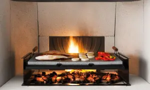 Top cucina pietra lavica: pro e contro. Pesce e verdure grigliati su pietra lavica, con brace ardente sotto.