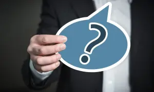 Dłoń trzyma chmurkę z pytajnikiem, symbolizującą najczęstsze dylematy moralne wierzących w świecie nowoczesnych technologii.