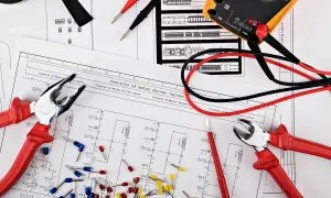 Narzędzia elektryka i schemat instalacji elektrycznej w domu.