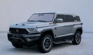 Szary mhero SUV o kanciastym designie, z masywnym grillem i ostrymi liniami.