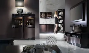 Elegancki salon z meblami w kolorze wenge. Kobieta w czarnej sukience wybiera książkę z regału.