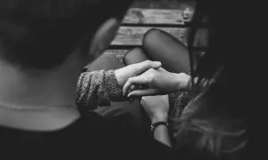 Manos entrelazadas, ¿es amor o dependencia emocional? La conexión se siente intensa en esta imagen en blanco y negro.