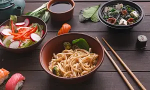 Sos sojowy do czego? Do makaronu, sushi i zupy. Pyszne azjatyckie dania na drewnianym stole.