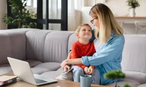 Mama tuli syna na kolanach, patrząc na niego z miłością. To jak wiersz dla syna od matki, pełen ciepła i bliskości.