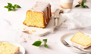 Ein saftiger Zitronenkuchen in Kastenform, mit Zuckerguss und bunten Streuseln verziert, wartet auf seine Genießer.