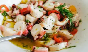 Ein köstlicher Pulpo Salat mit Tomaten und Dill in Olivenöl.