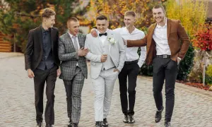 Pięciu mężczyzn w eleganckich garniturach i marynarkach, gotowych na męską stylizację na imprezę.