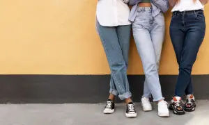 Trzy dziewczyny w szerokich jeansach i modnych sneakersach. Idealne inspiracje, jakie buty do szerokich spodni jeansowych.