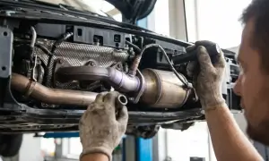 Mechanik sprawdza katalizator BMW, szukając przyczyny błędu DTC P0420.