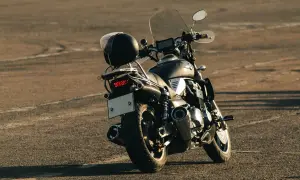 Czarny chopper z chromowanymi elementami i szybą. Kask na bagażniku. Idealny do modyfikacji, jak upiększyć choppera.