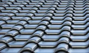 Szare dachówki ceramiczne tworzą falisty wzór na dachu. Ich waga zapewnia stabilność konstrukcji.