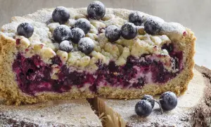 Saftiger Heidelbeerkuchen Landfrauenart mit Streuseln und frischen Beeren, bestäubt mit Puderzucker.