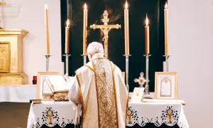 Kapłan w bogato zdobionej szacie odprawia mszę. Przed nim ołtarz z księgą i krzyżem. Świadectwo wiary, spowiedź powszechna.