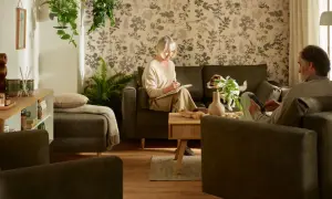 Przytulny salon, idealny, by pokazać, jak urządzić pokój dla babci. Starsza pani pisze, piesek czuwa.