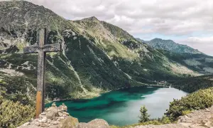 Kamienny krzyż na tle gór i Morskiego Oka. Czas przejścia do tego widoku był długi, ale wart każdego kroku.