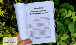 Otwarta książka z rozdziałem "Popatrz na siebie kochającymi oczami" zachęca do łagodnej, spokojnej akceptacji i samoakceptacji.
