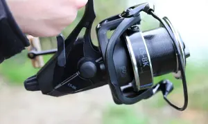 Kołowrotek Okuma 8K z wolnym biegiem, gotowy do akcji nad wodą.