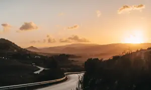 Kurvige Straße in Andalusien bei Sonnenuntergang. Berge und Täler in warmen Farben, ein Highlight der Landschaft.