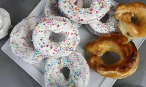 Biscotti a ciambella con glassa bianca e zuccherini colorati, pronti per essere gustati. La glassa per biscotti che si asciuga subito li rende perfetti.