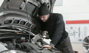 Mechanik z latarką bada silnik 1.9 TDI.