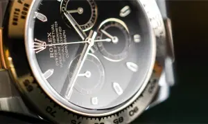 Primer plano de un Rolex Daytona con esfera negra y cristal hesalite. Los detalles del cronógrafo y la inscripción son visibles.
