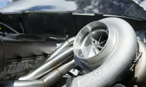 Błyszcząca turbosprężarka p0299 z wirnikiem i kolektorem wydechowym w silniku wyścigowym.