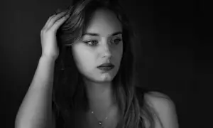 Kobieta z dłonią we włosach, w nastrojowym, low key fotografii.
