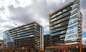 Nowoczesne apartamentowce z przeszklonymi fasadami odbijają chmury. Zastanawiasz się, dlaczego deweloperzy nie podają cen?