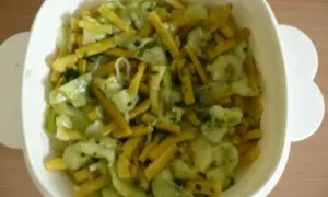 Frischer Bohnen Gurken Salat mit Kräutern in einer weißen Schüssel.