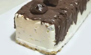 Pyszne lody cassate w kształcie bloku, oblane czekoladą i ozdobione czekoladowymi kuleczkami.