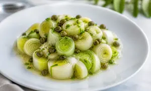 Poireaux vinaigrette, coupés en tronçons, nappés d'une sauce légère et parsemés de câpres. Un plat frais et savoureux.