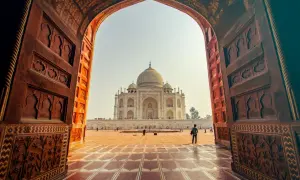 Widok na Taj Mahal przez zabytkowy łuk. Idealne miejsce na niezapomniane indie wakacje.