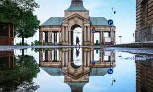Odbicie zabytkowej budowli w kałuży po deszczu. Warto zobaczyć to miejsce w Szczecinie, szczególnie po opadach.