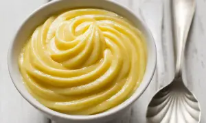 Una ciotola di cremosa crema pasticcera, liscia e invitante, pronta per essere gustata.