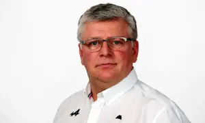 Otmar Szafnauer, con gafas y camisa blanca con logo de Alpine, mira fijamente.