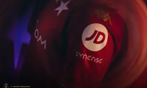 Czerwona koszulka Wisły Kraków z logo JD i Synerise. Widoczne też logo Kappa i gwiazda.