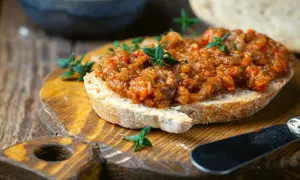 Pyszna pasta z bakłażana na chrupiącym pieczywie, ozdobiona świeżymi ziołami. Idealna na przekąskę.