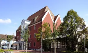 Das Handwerksmuseum Deggendorf präsentiert sich in einem modernen Gebäude mit auffälliger Glasfront und roten Fassaden.