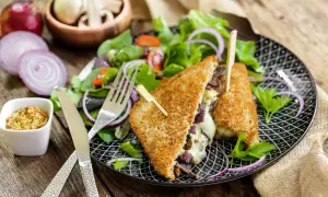 Un délicieux croque monsieur végétarien garni de champignons et de fromage fondant, servi avec une salade fraîche et de la moutarde à l'ancienne.