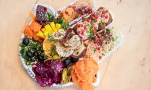 Kolorowy talerz pełen hummusów, falafeli i warzyw. Idealna propozycja dla szukających restauracji wegańskiej w Gdańsku.