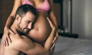 Czuły mężczyzna obejmuje brzuch ciężarnej kobiety. Delikatne pozycje seksualne w ciąży, pełne miłości i bliskości.