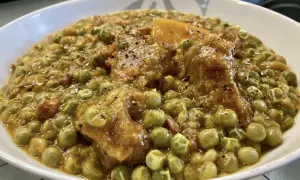 Un saporito spezzatino con piselli, teneri pezzi di carne e verdure in un sugo denso e profumato, pronto per essere gustato.